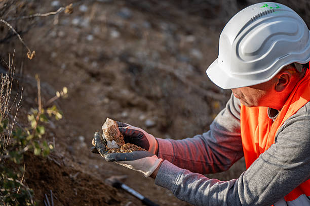 istock Geologist searching for and examining minerals in an open-air quarry. Tools, hammer... a precious piece of mineral. Geology in winter. 2249099544