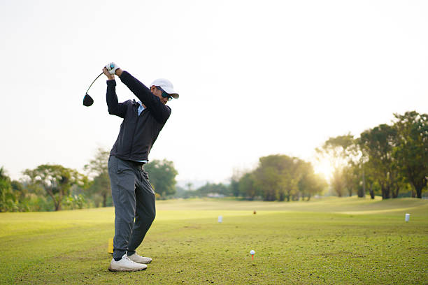 istock Golfer performing a powerful tee off swing on bright scenic fairway. 2249111764
