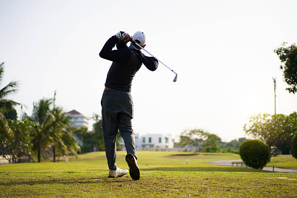 istock Golfer performing a powerful tee off swing on bright scenic fairway. 2249111769