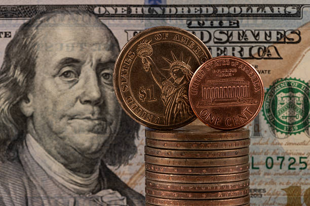 istock A US 1 cent coin and a US $1 dollar coin against a US $100 bill 2249114185