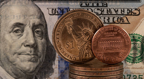 istock A US 1 cent coin and a US $1 dollar coin against a US $100 bill 2249114186