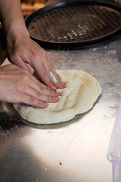 istock Hands Kneading Pizza Dough on Floured Countertop in Kitchen 2249115394