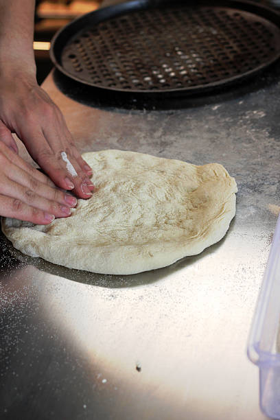 istock Hands Kneading Pizza Dough on Floured Countertop in Kitchen 2249115509