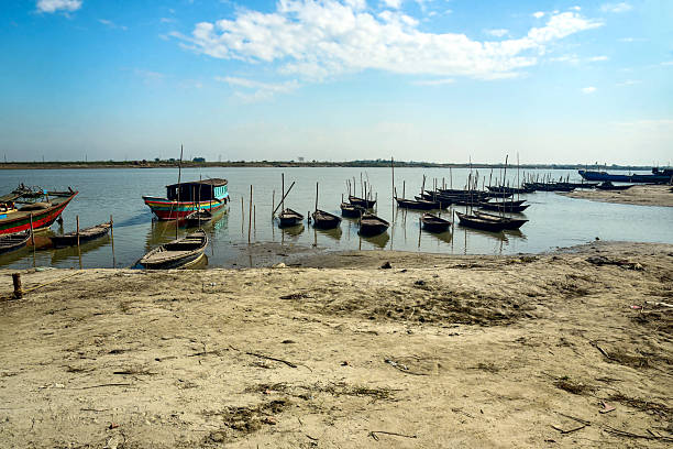 istock Colorful Boats Anchored Along a Quiet River Shore Under a Bright Blue Sky 2249120360