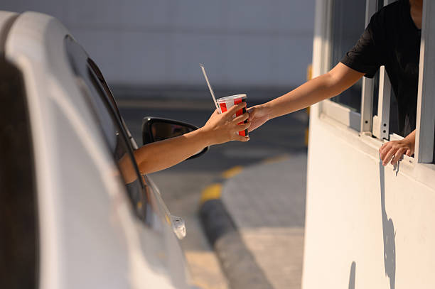 istock Customers receive coffee cups from drive-thru counter staff during rush hour. 2249122312