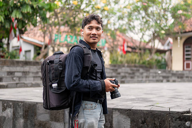 istock Indonesian photographer walking with camera and backpack outdoors 2249130812