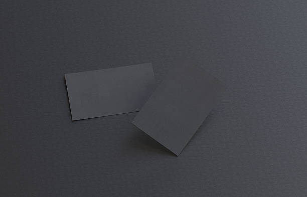 istock Two black blank business cards mockup on black table background 2249131564
