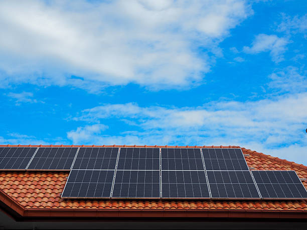 istock Solar panels on a terracotta roof under a blue sky and clouds 2249133252