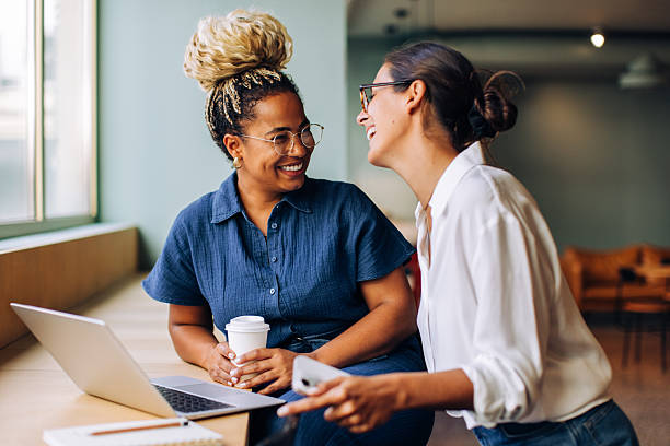 istock Two women enjoying a cheerful conversation by a laptop 2249134208