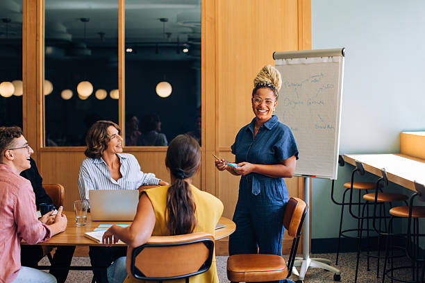 istock Smiling presenter leading a group discussion in a well-lit conference room 2249134442