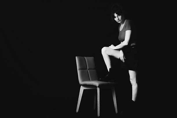istock Black‑and‑White Portrait with Chair and Contrasting Pose 2249137834