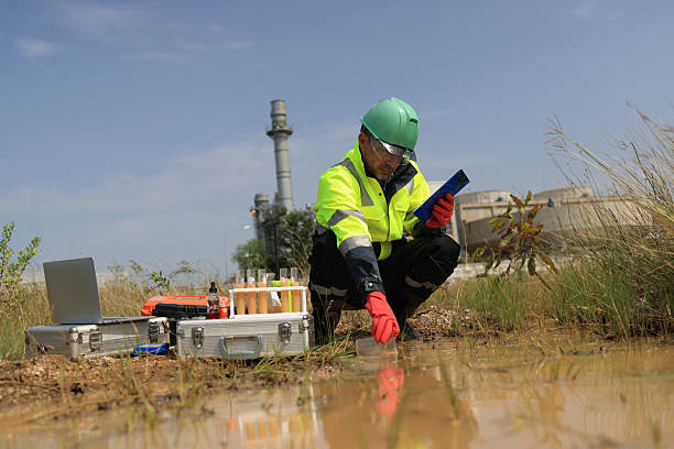 istock An environmental engineer wearing green safety gear is sampling and testing water around the factory 2249141838