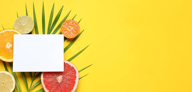 istock Summer tropical composition with a white card. Green leaf and tropical fruits on a colored background. Summer concept. Flat lay, top view, copy space 2249145011
