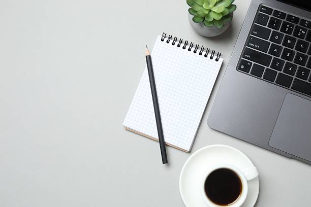 istock Workplace with notebook, laptop and coffee cup, top view 2249146672