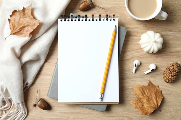 istock Autumn decor and notebook, pencil, cup of coffee on wooden background 2249146708