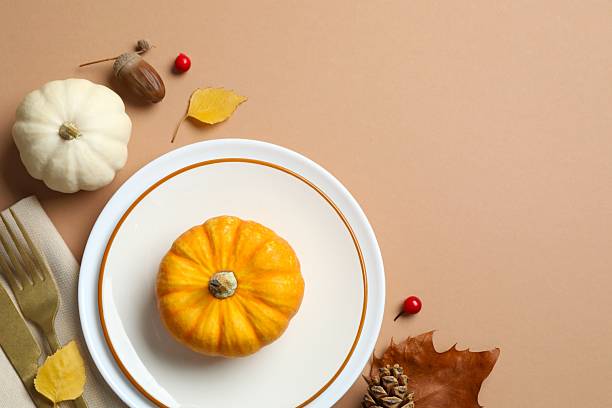 istock Thanksgiving day. Close-up of table setting with pumpkins, dinnerware, rustic napkin on a plates 2249146888