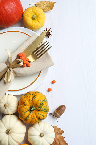 istock Close-up of table setting with pumpkins, dinnerware, rustic napkin on a plates. Thanksgiving day 2249147806