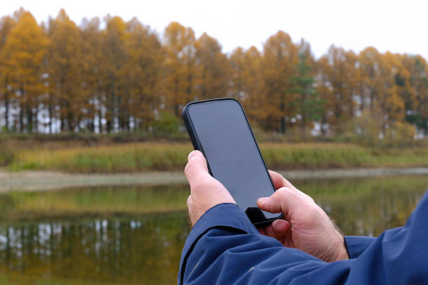 istock Person holding smartphone displaying blank screen in autumn nature 2249148017