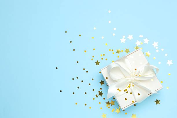 istock Beautiful gift box with golden confetti on color background 2249149249