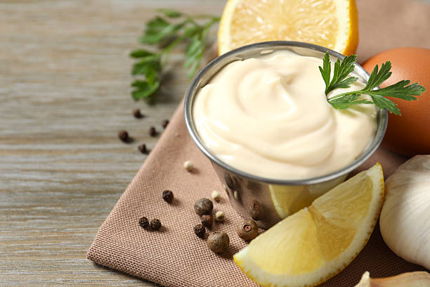 Bowl with mayonnaise and ingredients for cooking on the table