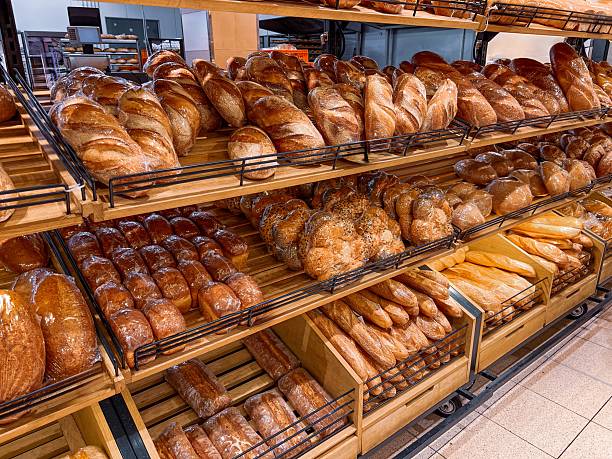 Food commerce and everyday shopping. Sale of bread with a close-up view of bakery products on shelves in a store or bakery.