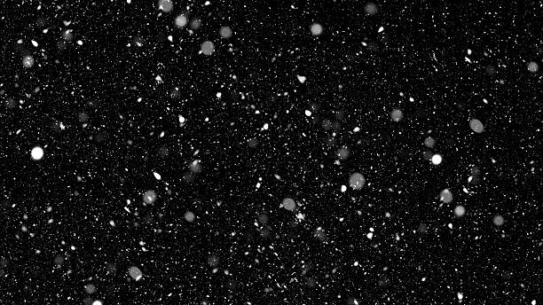 istock Heavy snowfall effect with large, blurred, white snowflakes and smaller particles falling rapidly against an isolated black background 2249155156
