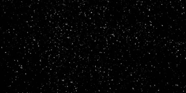 istock Snow overlay with small, irregularly shaped white particles falling against an isolated dark black background 2249155157