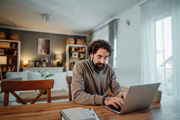 istock Man working remotely with laptop at home office 2249156486