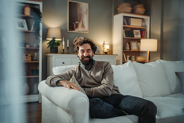 istock Happy man relaxing on sofa at home 2249158340