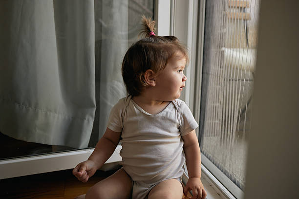 istock Toddler girl looking out window exploring world 2249158888