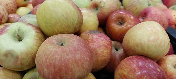 istock Red and yellow apples in a market stall. 2249159033