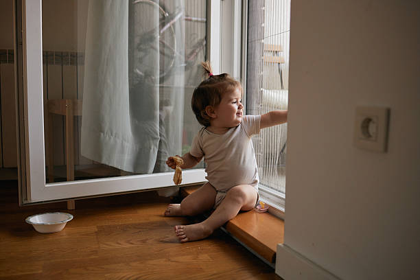 istock Baby girl exploring window at home 2249159365