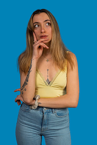 istock Young woman thinking looking up against blue background 2249162112