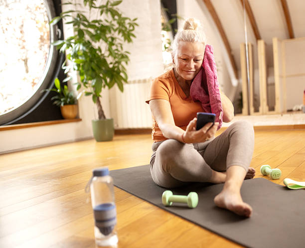istock senior woman relaxing after workout and checking her phone 2249166027