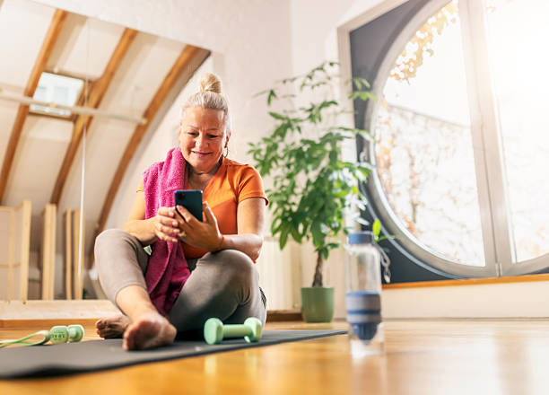 istock senior woman relaxing after workout and checking her phone 2249166040