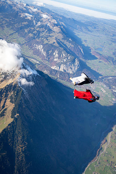 istock Wingsuit fliers fly side by side over snowcapped mountains 2249167494