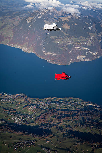 istock Wingsuit fliers soar above lake and mountains 2249167536