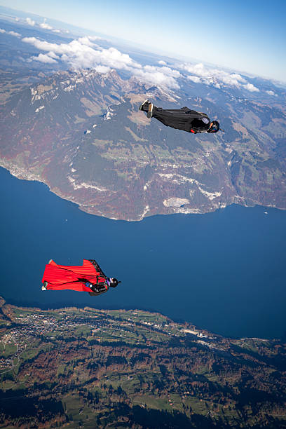 istock Wingsuit fliers soar above lake and mountains 2249167540