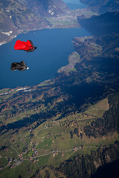 istock Wingsuit fliers soar above lake and mountains 2249167566