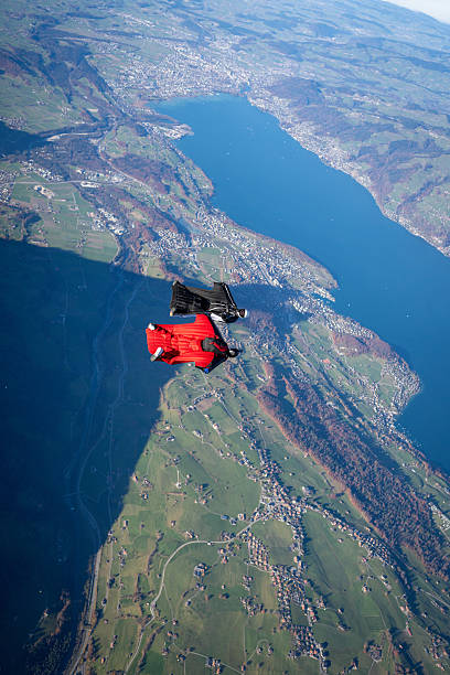 istock Wingsuit fliers soar above lake and mountains 2249167597