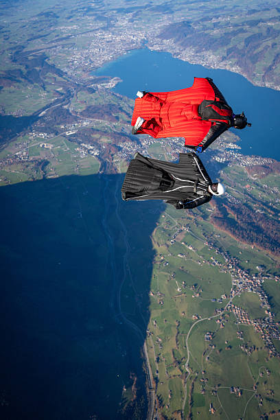 istock Wingsuit fliers soar above lake and mountains 2249167598