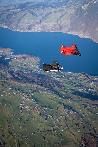 istock Wingsuit fliers soar above lake and mountains 2249167632
