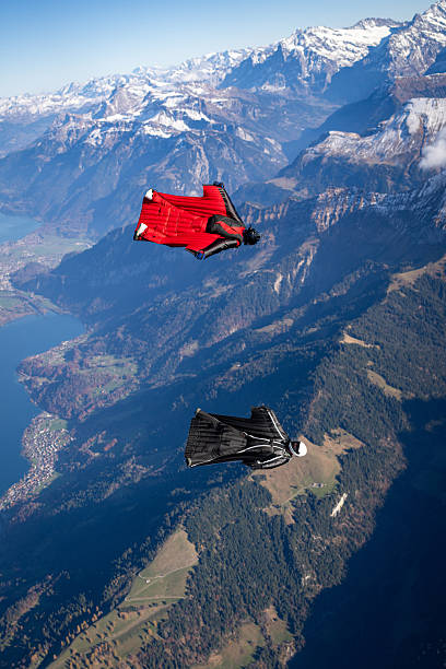 istock Wingsuit fliers soar above lake and mountains 2249167657