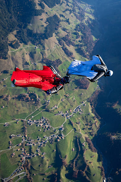 istock Wingsuit fliers fly side by side over snowcapped mountains 2249167710