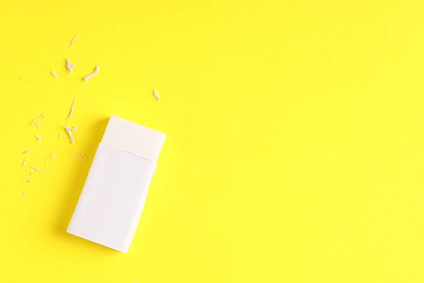 istock One eraser and scraps on yellow background, top view. Space for text 2249169793