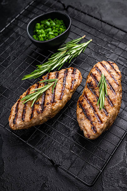istock Grilled kofta kebabs made from spiced minced meat, perfectly grilled and served with fresh herbs and tangy sauce. black background. top view 2249169934