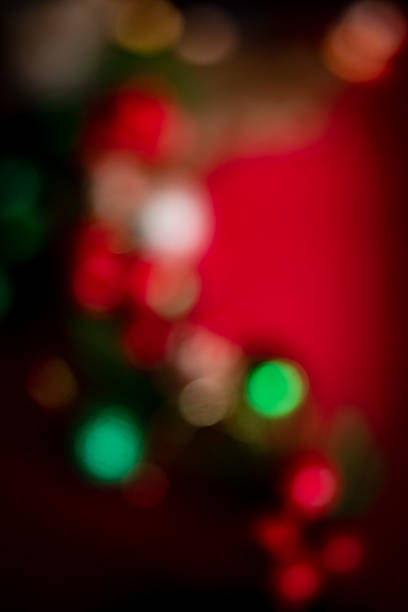 Soft, colorful bokeh lights in red, green, and gold tones creating a festive and dreamy abstract background suitable for holiday and celebration themes.