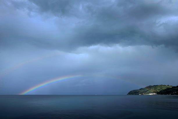 Sea with rainbow at the beach in the evening light near Pontikinisi at Corfu Greece. Mediterranean Sea culture