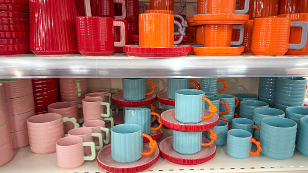 istock Colorful ceramic mugs and plates displayed on store shelves. Bright modern tableware in vibrant pastel tones, arranged neatly and ready for home decor or kitchenware shopping concepts. 2249177572