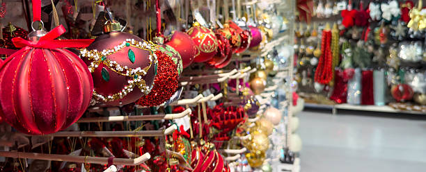 istock Bright red holiday ornaments with glitter, beads and decorative details displayed on store shelves. Festive baubles hanging in a shop aisle filled with colorful seasonal decorations. 2249184423
